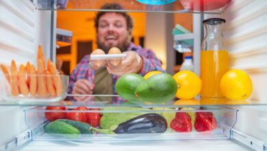 A man takes eggs from a refrigerator.