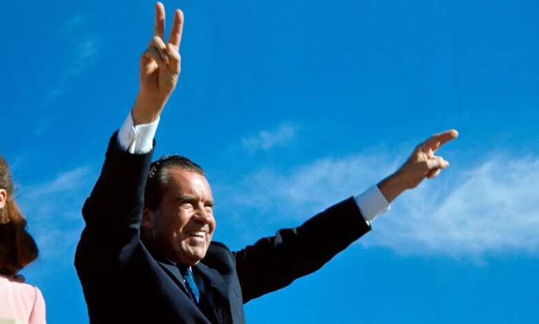 Richard Nixon greeting people with his arms up