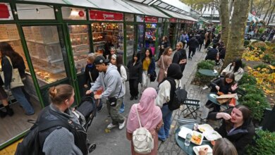 People shopping and eating at market stalls at Bryant Park, New York City.