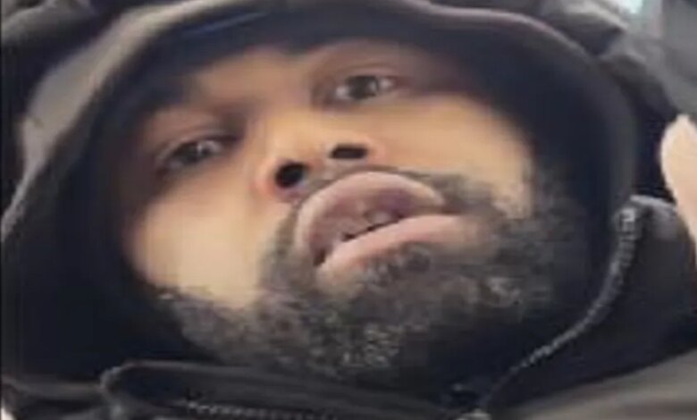 Close-up of a man with a beard and dark hooded jacket, identified as a person of interest by Crime Stoppers.