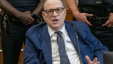 Harvey Weinstein speaking in court while surrounded by officers.