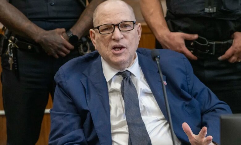 Harvey Weinstein speaking in court while surrounded by officers.