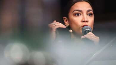U.S. Representative Alexandria Ocasio-Cortez speaking into a microphone at the Munich Security Conference.