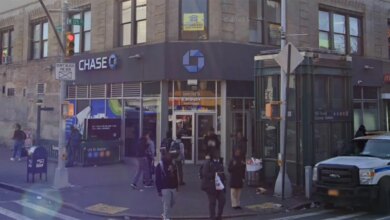 Street view of West 125 Street and St. Nicholas Avenue in New York City, featuring a Chase bank branch and a subway station entrance.