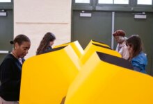 People voting in yellow voting booths.