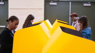 People voting in yellow voting booths.