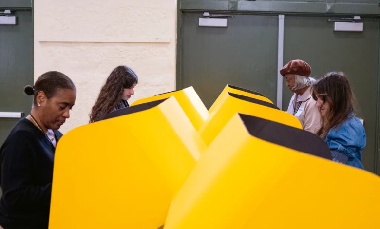 People voting in yellow voting booths.