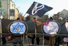 Demonstrators in Leipzig hold signs in protest of antisemitism.