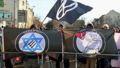 Demonstrators in Leipzig hold signs in protest of antisemitism.