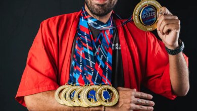 Anthony Simonetti holding medals for completing 7 marathons on 7 continents in 7 days.