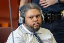 Randy Santos in a light-colored button-up shirt and patterned tie with headphones, seen during his trial.