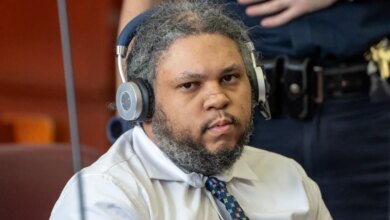 Randy Santos in a light-colored button-up shirt and patterned tie with headphones, seen during his trial.
