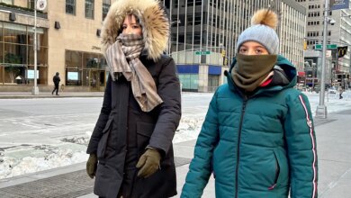 Two people are bundled up against freezing cold in Midtown Manhattan.