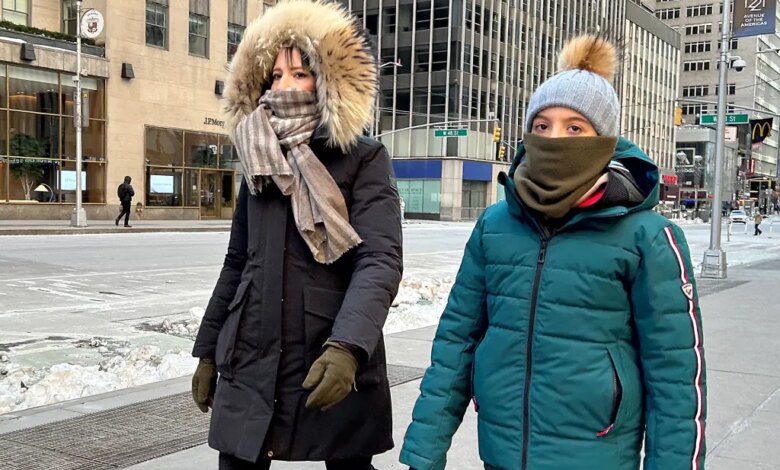 Two people are bundled up against freezing cold in Midtown Manhattan.
