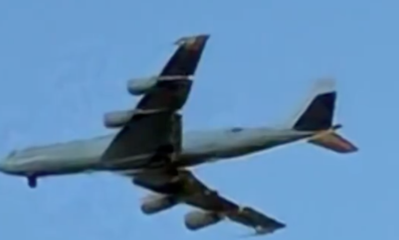 A Boeing E-6B Mercury "Doomsday Plane" flying through a blue sky.