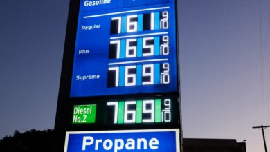 Gas prices displayed on a sign for Regular, Plus, Supreme, and Diesel No. 2 all showing $7.69 and 9/10, with a separate sign for Propane below.