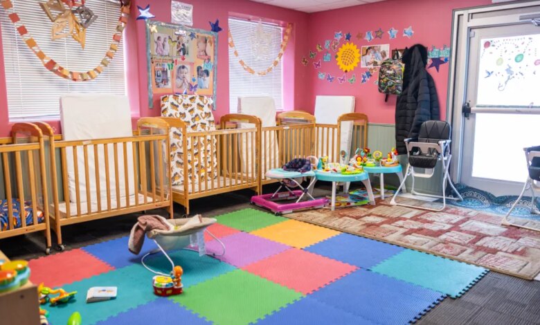 Daycare room with multiple cribs, playmats, and toys.