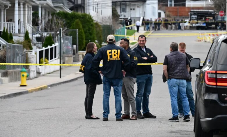FBI agents and law enforcement gather at a crime scene blocked off by yellow police tape.
