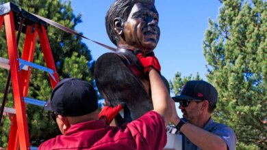 Workers removing a bust of Cesar Chavez from a park.