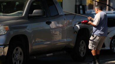 A man refuels his truck at a gas station.