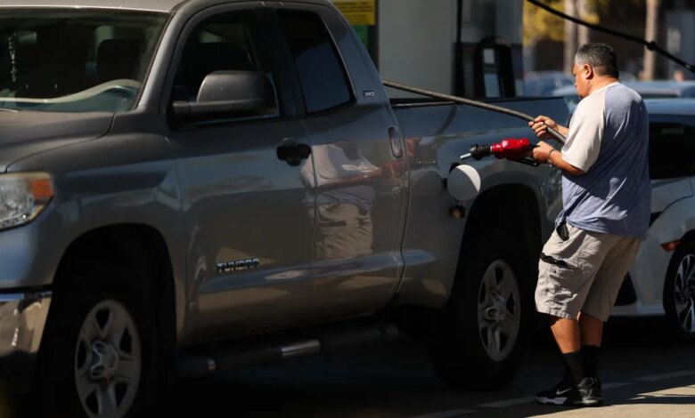 A man refuels his truck at a gas station.