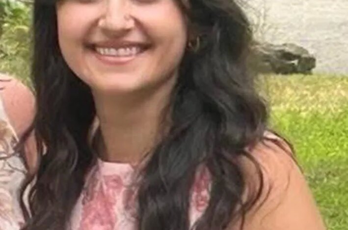 Brittany Kritis-Garip, a missing woman from Nassau County, smiling while wearing a pink floral top.