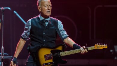 Bruce Springsteen performing on stage with a guitar.