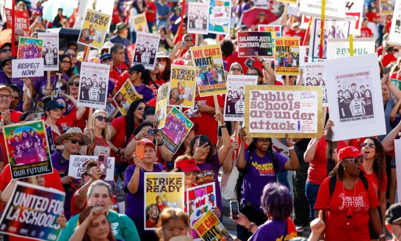 A crowd of Los Angeles Unified School District (LAUSD) employees and union members holding signs with messages like "Public schools are under attack!" and "Strike Ready".