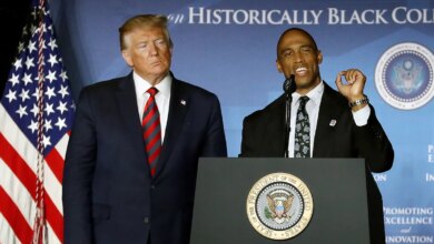 President Donald Trump standing next to HUD Secretary Scott Turner.
