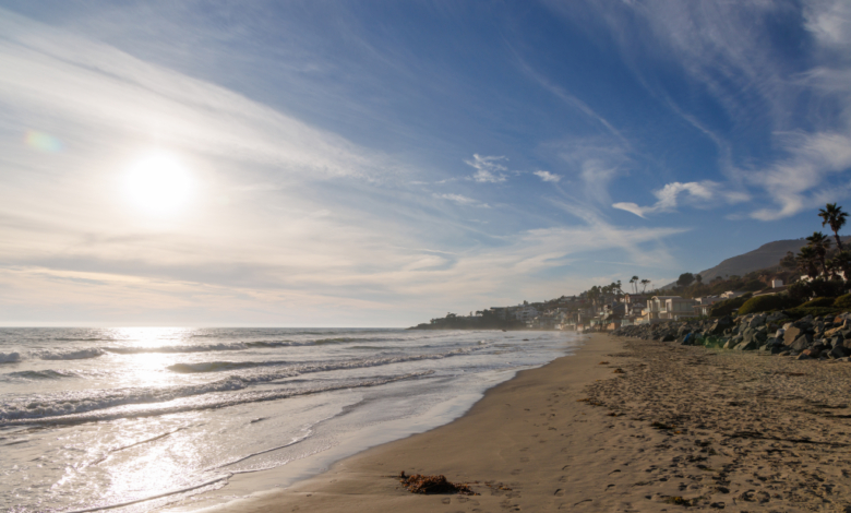 Ocean coast in Malibu, California with residential buildings along the shore.