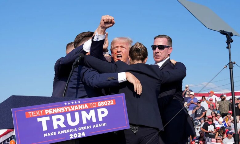 Former President Donald Trump raising his arm with blood on his face at a rally in Butler, Pennsylvania