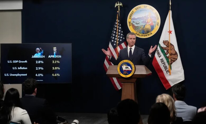 Governor Gavin Newsom speaks at a podium next to a screen displaying US economic statistics and images of Joe Biden and Donald Trump.
