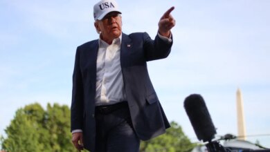 Donald Trump speaks to reporters outside the White House, gesturing with his right hand.