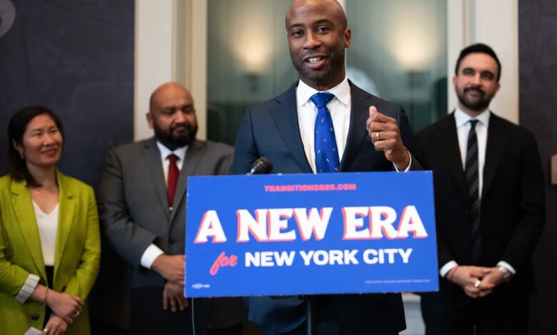 Kamar Samuels speaking at a podium with "A NEW ERA for NEW YORK CITY" on it, with three people standing behind him.