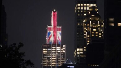 Building illuminated with the Union Jack flag at night.