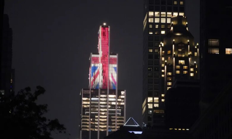 Building illuminated with the Union Jack flag at night.