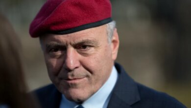 Close-up of Curtis Sliwa wearing a red beret, blue shirt, and blue tie.