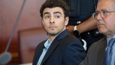 Luigi Mangione, accused of killing UnitedHealthcare CEO Brian Thompson, looking right from a courtroom.