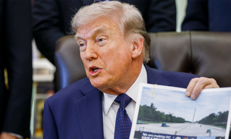 Trump holding up a photo of the progress on the National Mall's reflecting pool