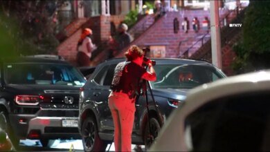 A NYPD Crime Scene Unit member photographs the scene of a shooting in Brooklyn, NY.