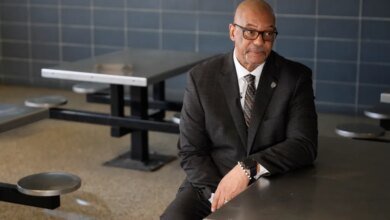 Stanley Richards, NYC Department of Correction commissioner, sits at a metal table in the housing unit of Rikers Island.