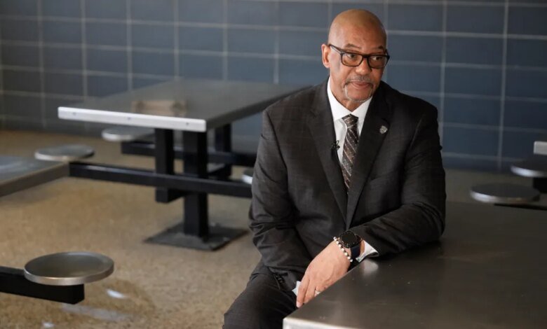 Stanley Richards, NYC Department of Correction commissioner, sits at a metal table in the housing unit of Rikers Island.