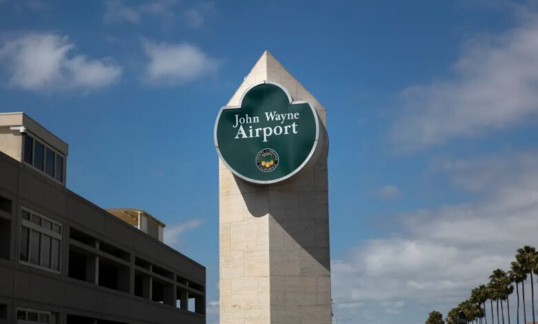 John Wayne Airport sign under a blue sky.