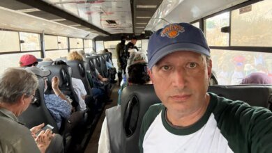 Brad Lander taking a selfie inside a crowded bus with other detained individuals.