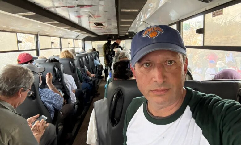 Brad Lander taking a selfie inside a crowded bus with other detained individuals.