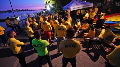 Competitors in the NYC Triathlon gather at the starting line alongside the Hudson River.