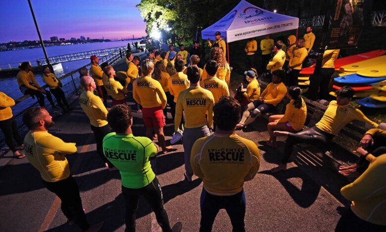 Competitors in the NYC Triathlon gather at the starting line alongside the Hudson River.