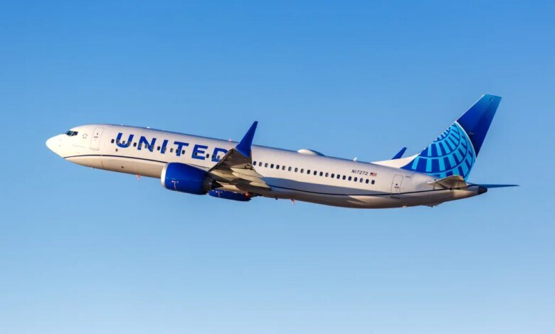United Boeing 737 MAX 8 airplane taking off against a clear blue sky.